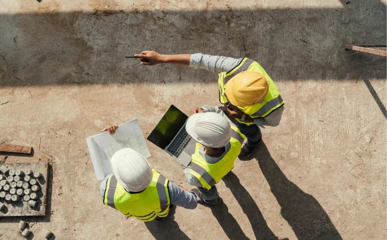 Construction workers reviewing plans on site
