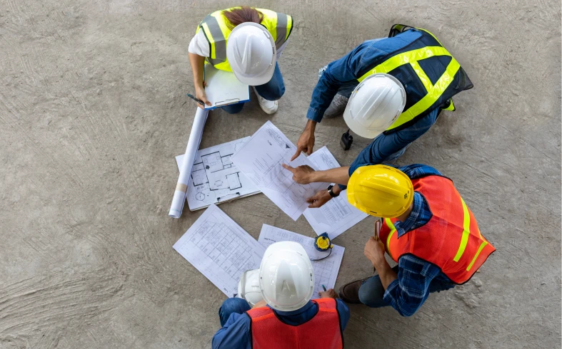 Workers collaborating over building designs